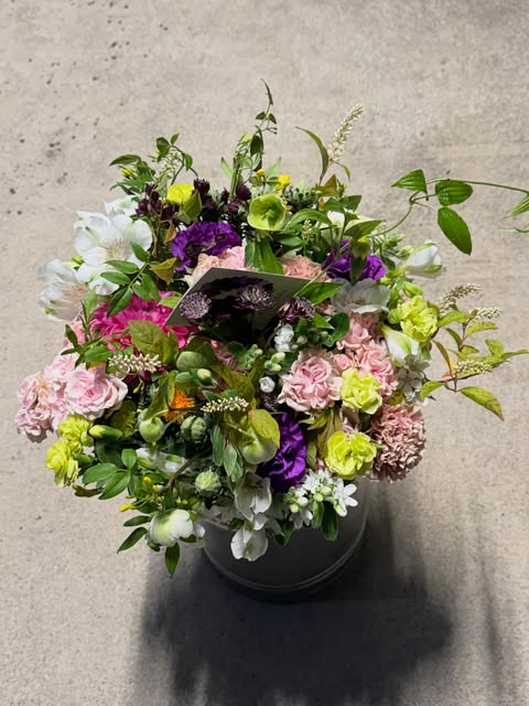 ピンク・紫・ライムグリーンの花を重ねたアレンジメント